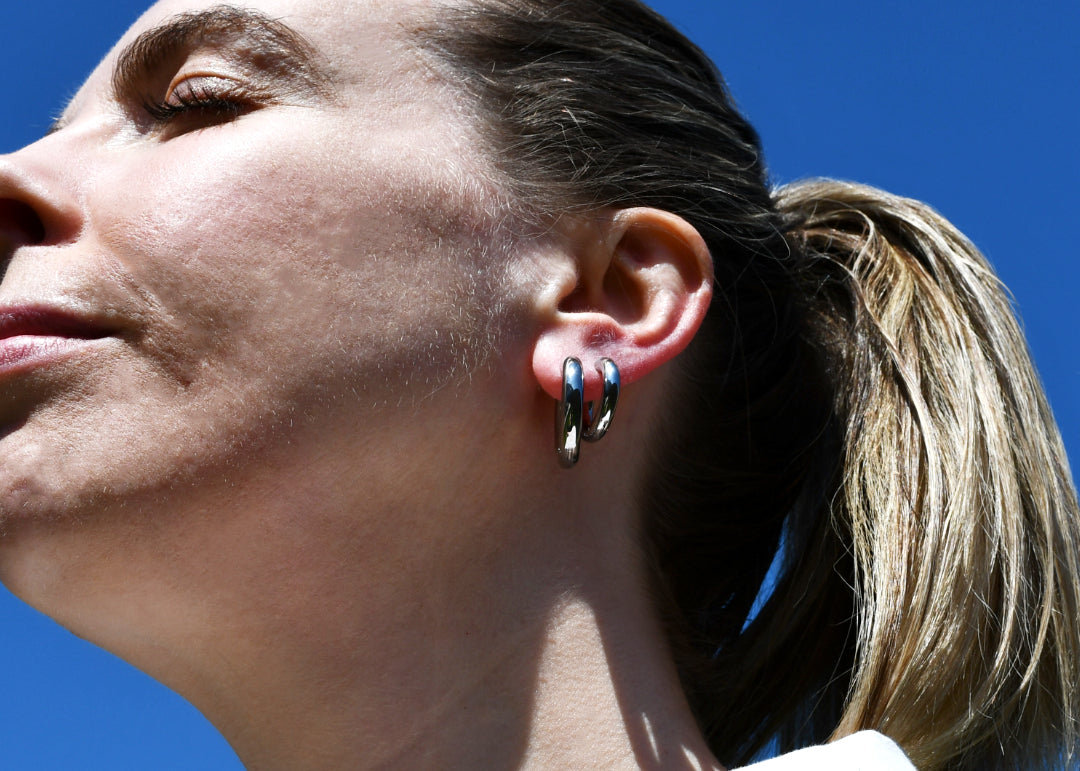 Woman wearing Lorraine Hoop Silver Earrings blue sky