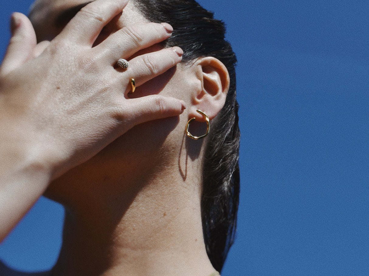 Woman wearing Lulu Cascades Stud Gold Earrings