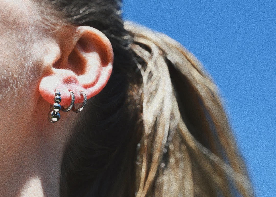 Woman wearing Rita Hoop Earrings layered with another 2 mini earrings