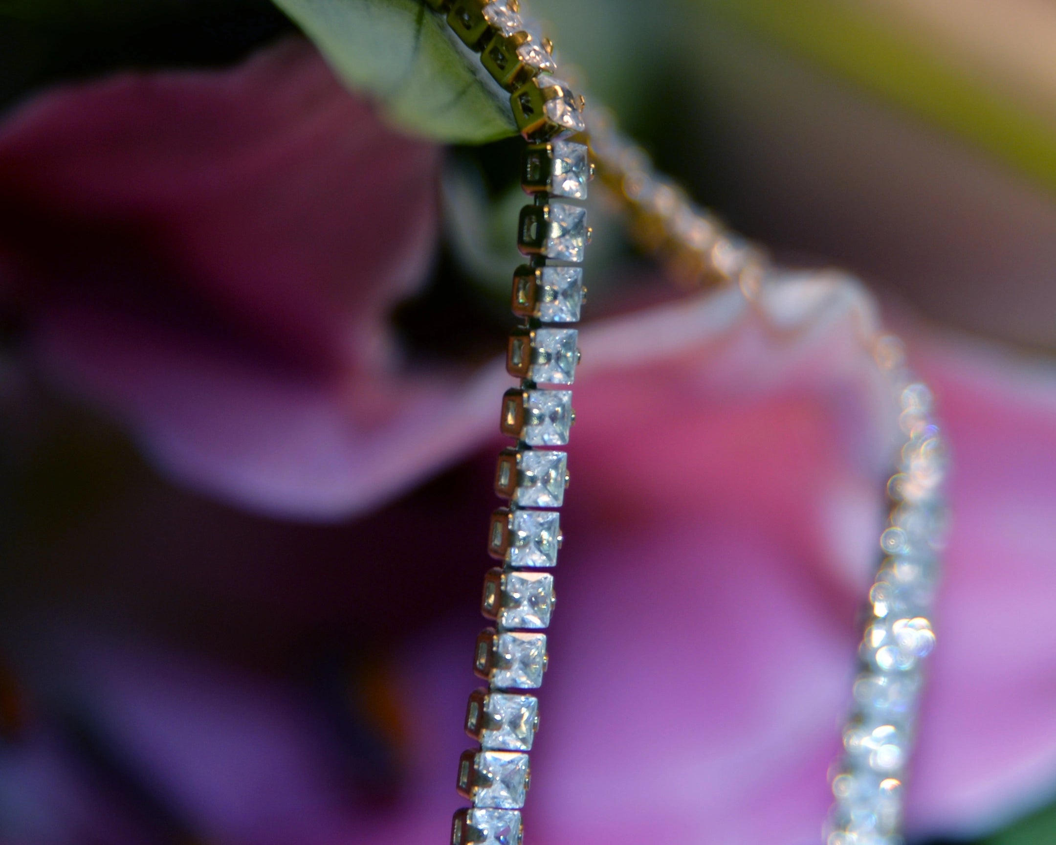 Artistic image of Aria's Tennis Chain Necklace on flowers