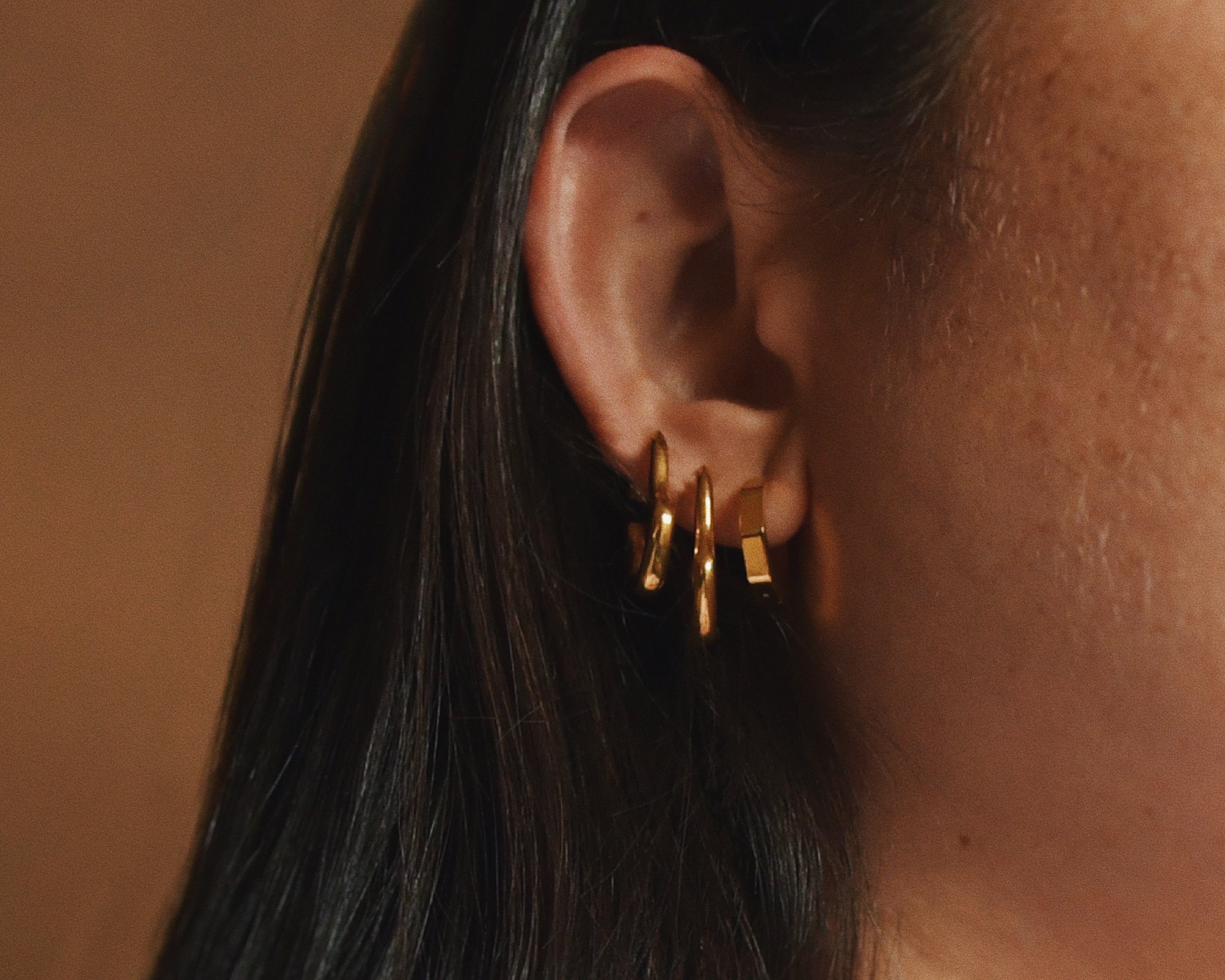 Woman wearing Geometry Small Huggies Gold Earrings