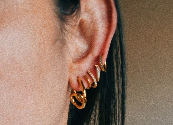 Woman wearing Loop Hoop Earrings and other earrings layered.