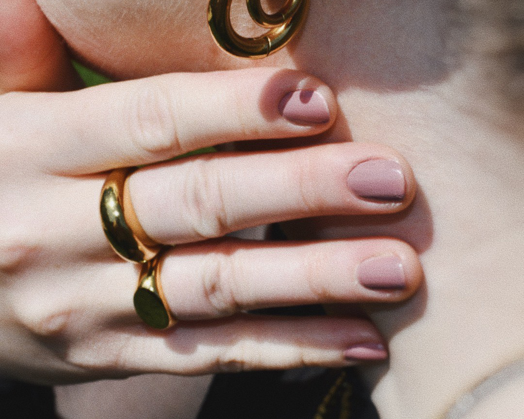 Woman wearring Lorraine Hoops Gold Earrings II and rings