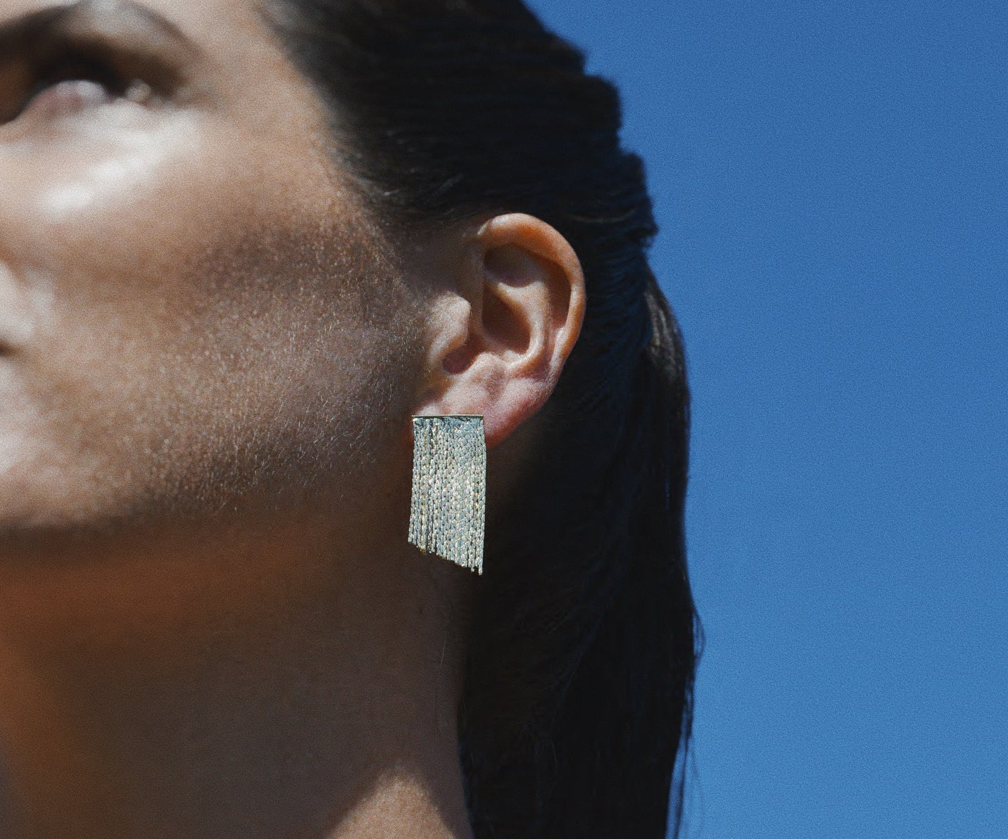 Woman wearing Lulu Cascades Stud Gold Earrings