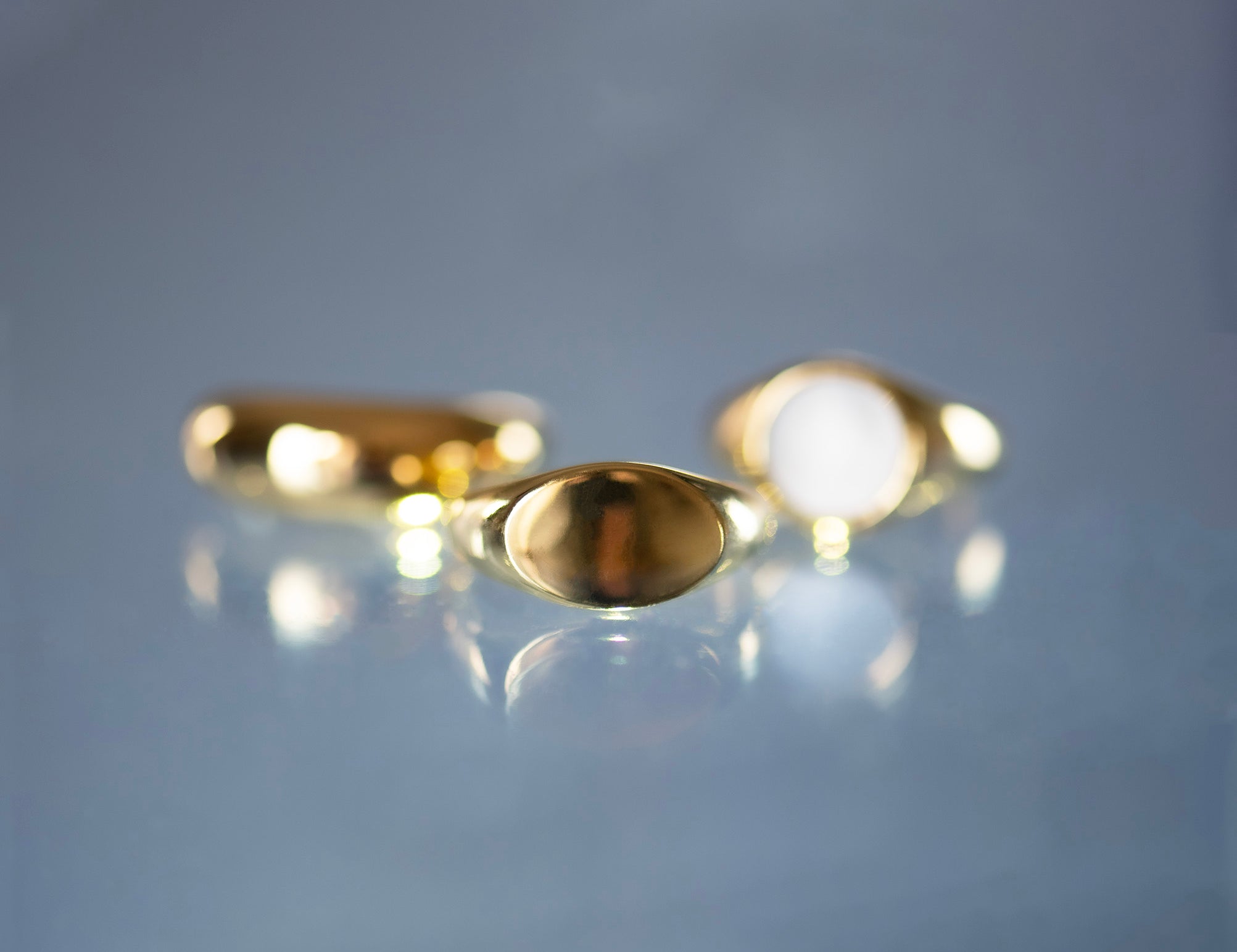 Artistic image of the Signature Signet Gold Ring with another two rings