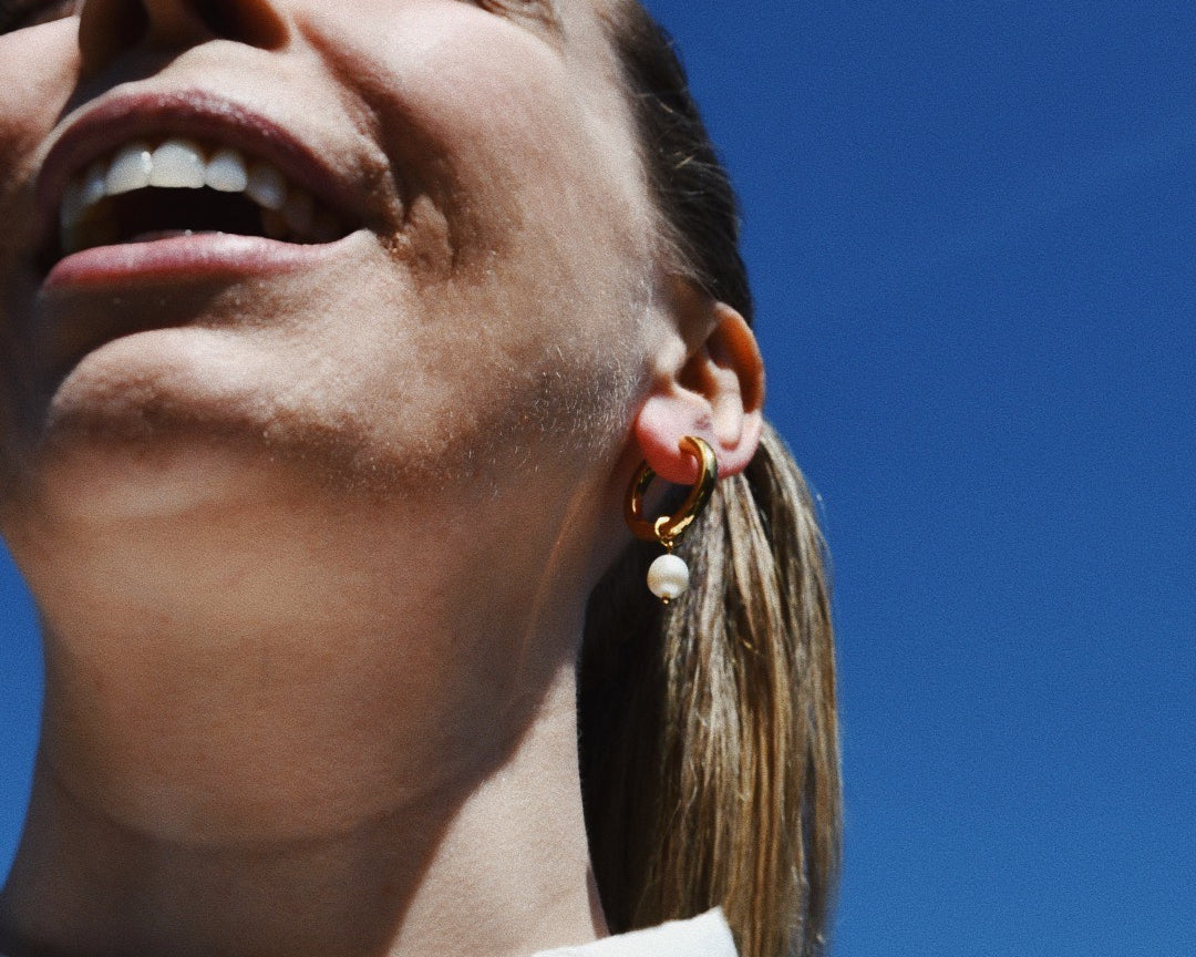 Smiling Woman wearing Pearl Medium Gold Hoop Gold Earrings