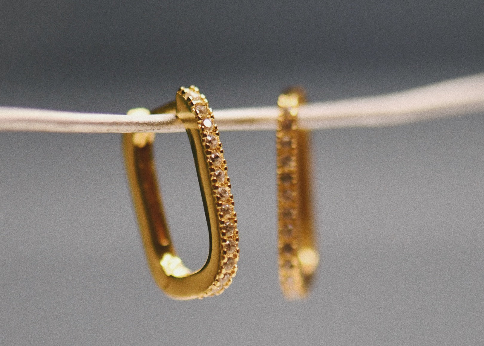 The Pavé Crystal Oval Hoops hanging on wire