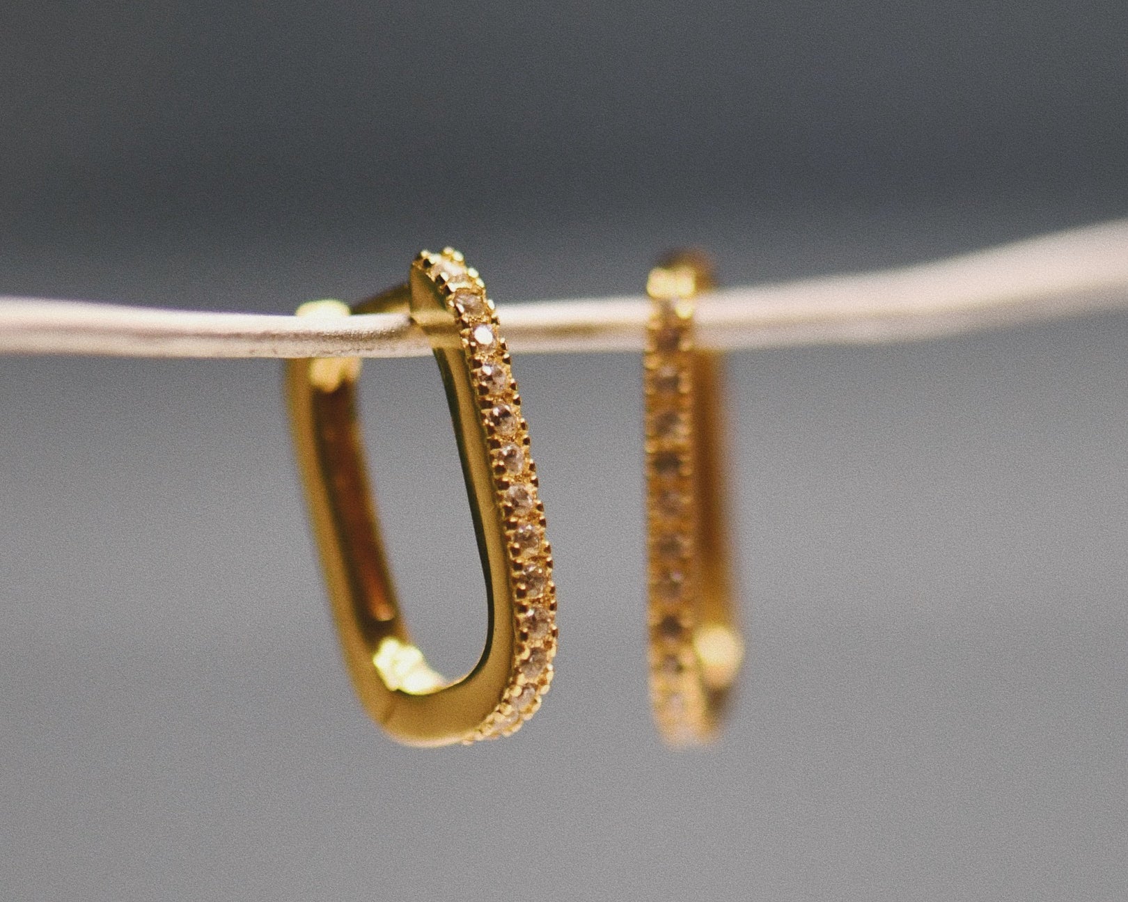 The Pavé Crystal Oval Hoops hanging on wire