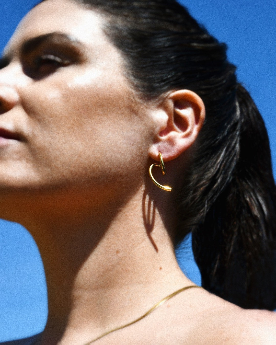 Stylish woman wearing the Edge Gold Stud Earrings, minimalist design