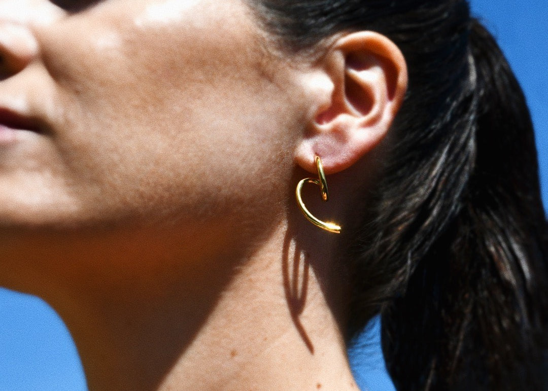 Stylish woman wearing the Edge Gold Stud Earrings, minimalist design