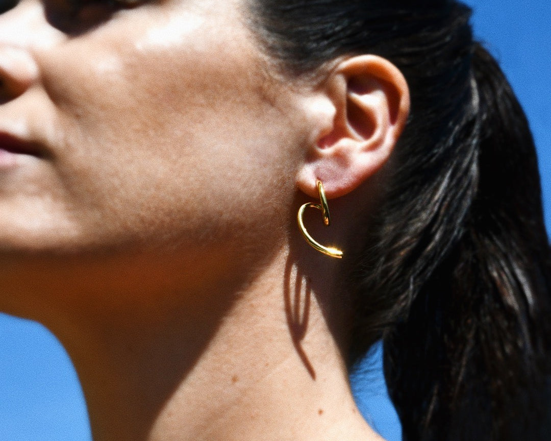 Stylish woman wearing the Edge Gold Stud Earrings, minimalist design