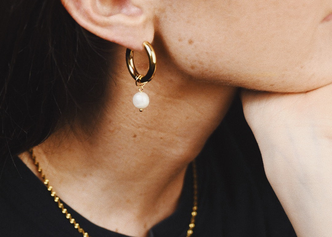 Woman wearing Pearl Medium Gold Hoop Earrings and twisted gold necklace