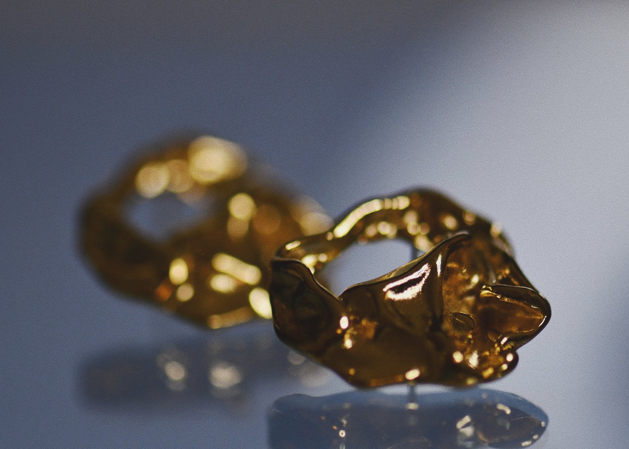 Close-up of a pair of Molten-oversized-gold-stud-earrings